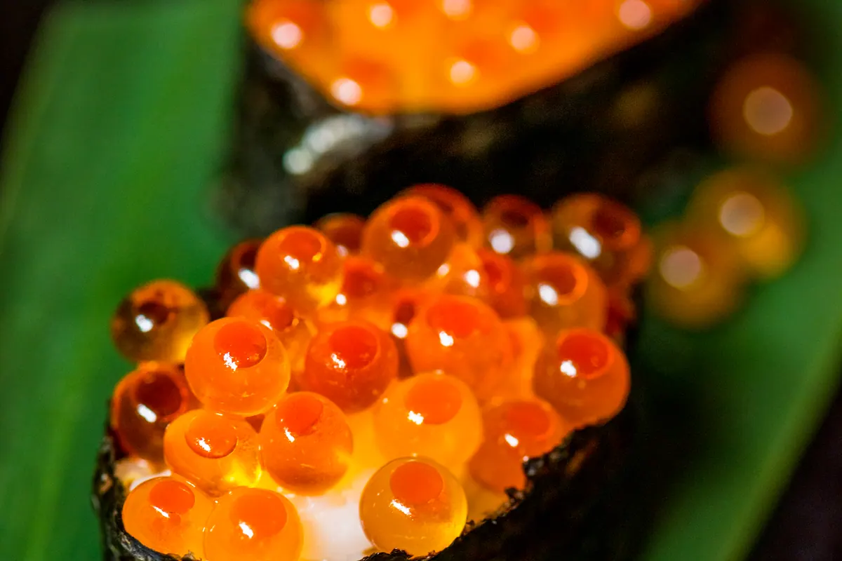 Salmon roe gunkan on a green leaf