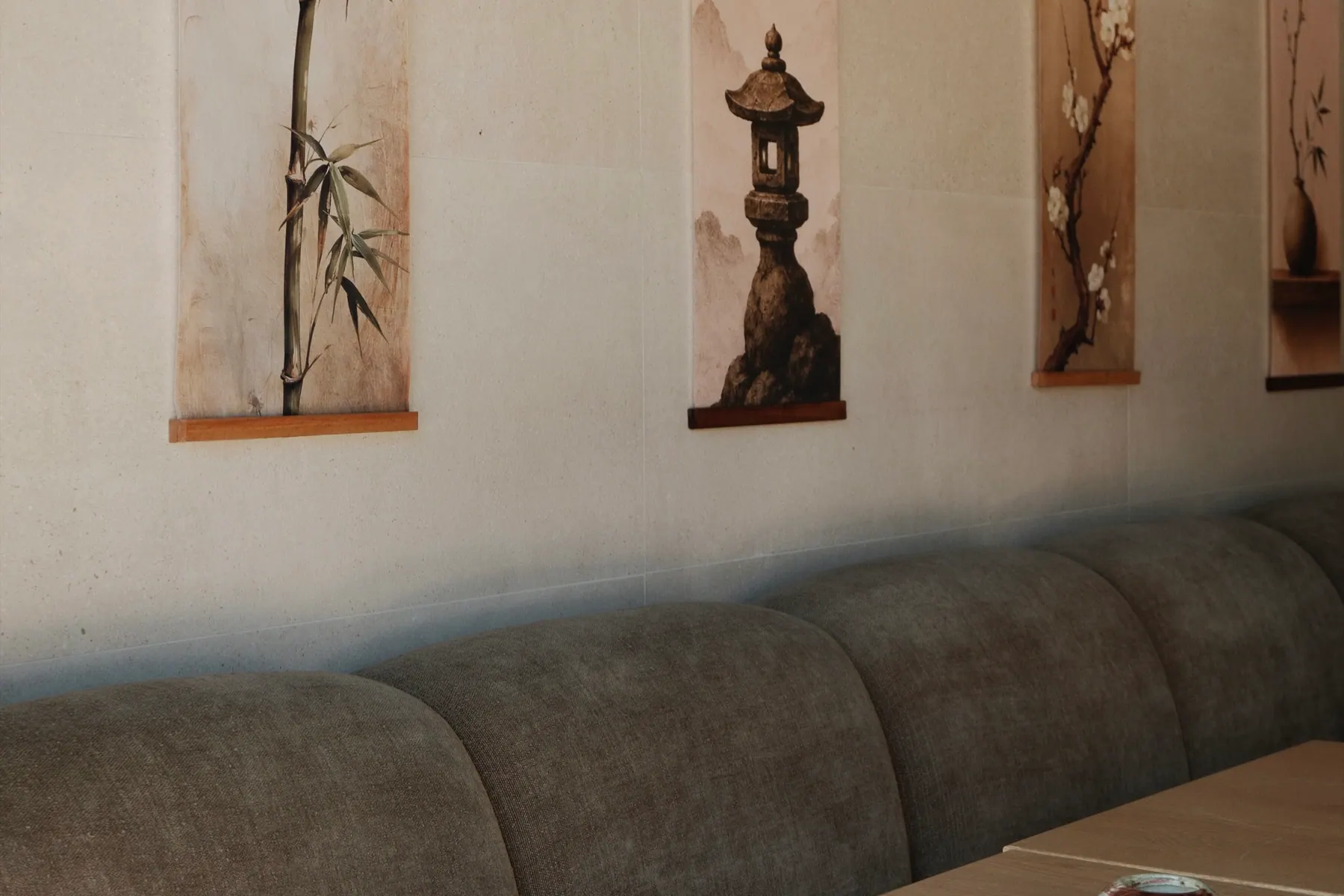 The dining room, banquette seating beneath the hanging scrolls